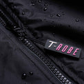 Image of water droplets on the surface of the black and pink T-Robe showcasing the waterproof capabilities