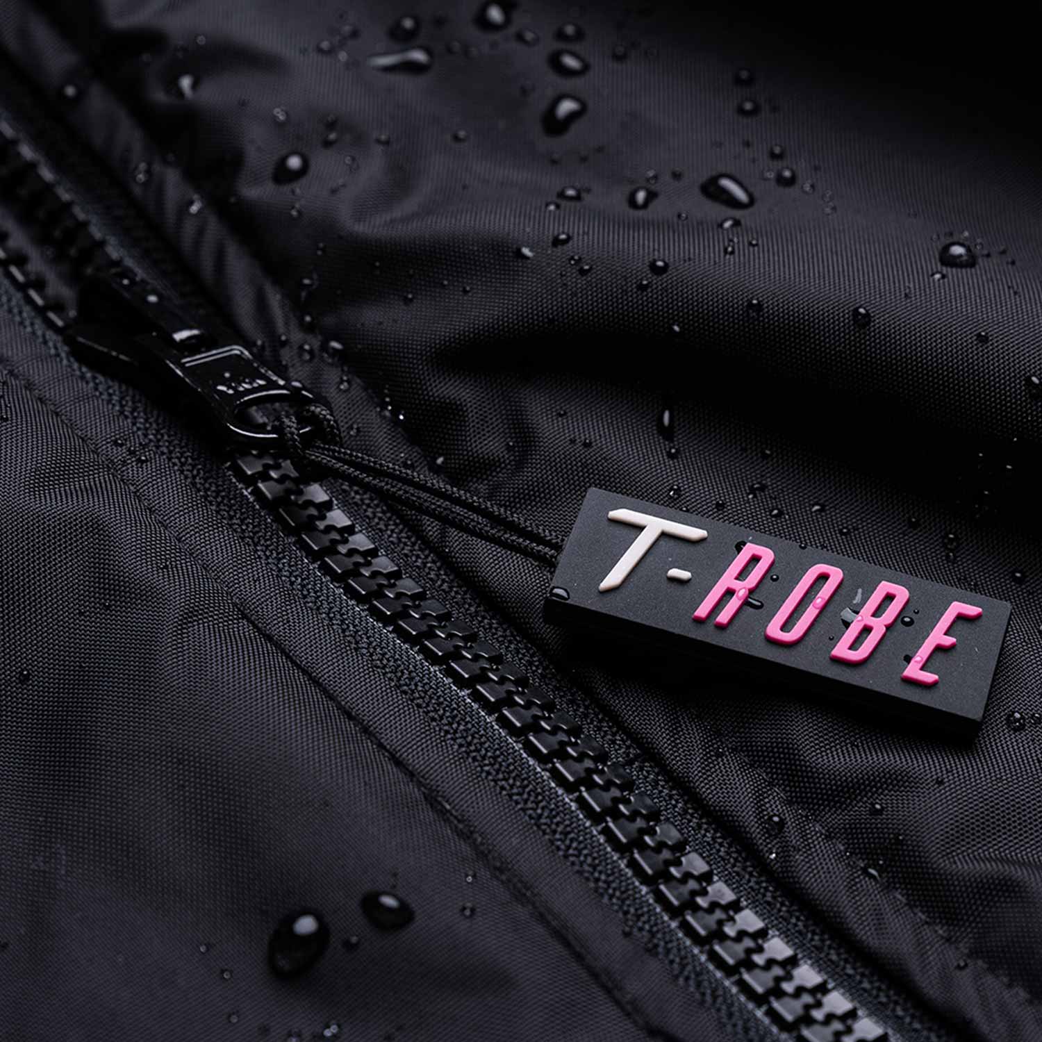 Image of water droplets on the surface of the black and pink T-Robe showcasing the waterproof capabilities